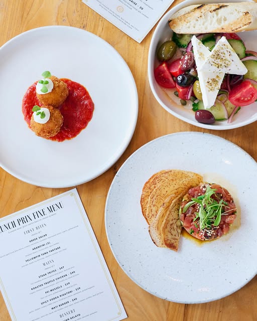 Mediterranean lunch dishes including Greek salad, arancini with tomato sauce, and tuna tartare with crisps, served at Mati restaurant in Ottawa